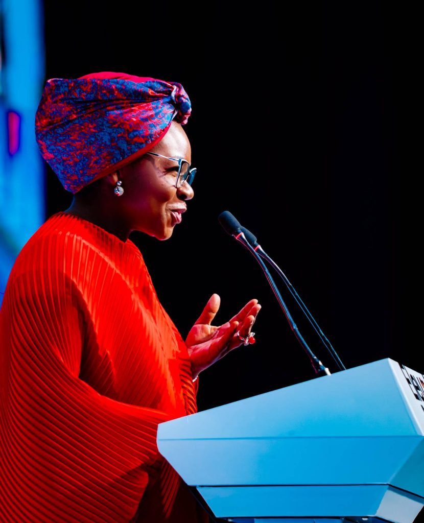 african lady in bright red gown and african ankara headpiece