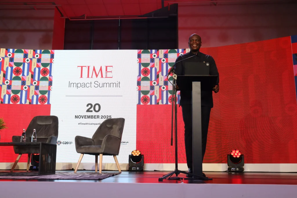 man at podium of event at time impact summit
