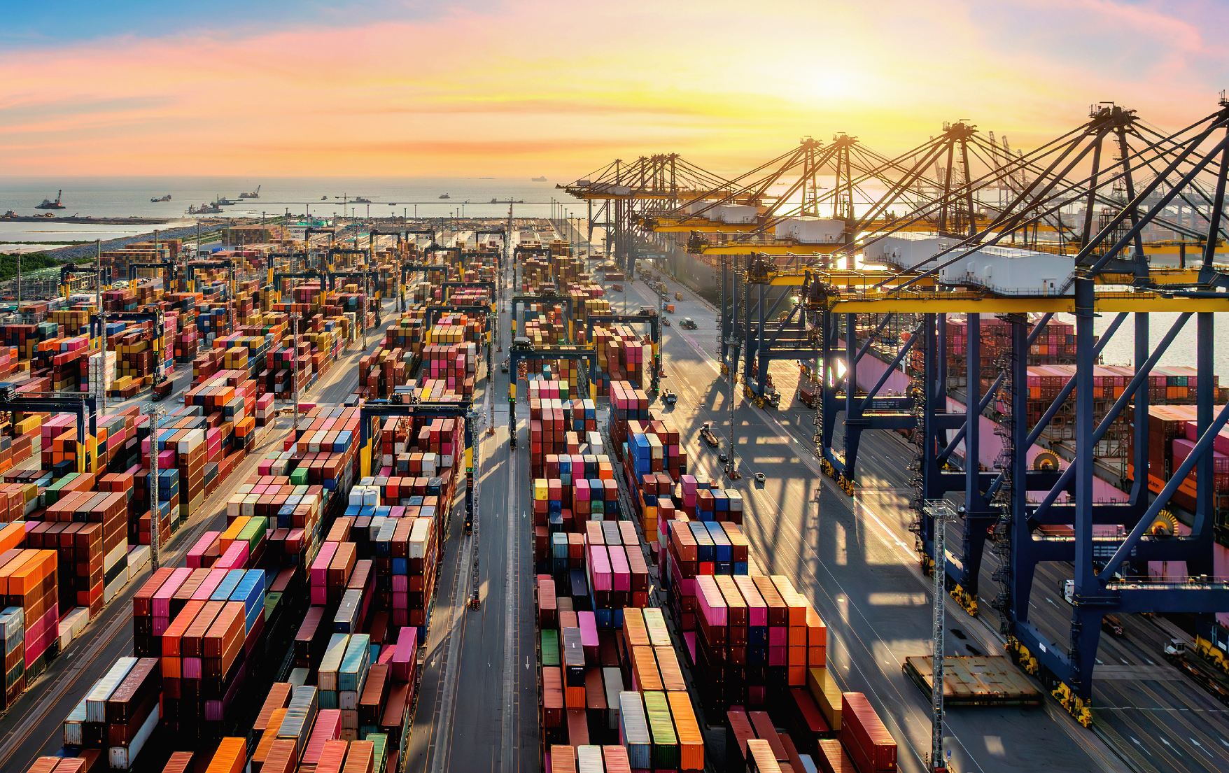 Large modern African container port at sunset with cranes and shipping containers.