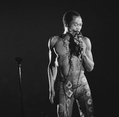 Black and white photo of Fela Kuti performing on stage, embodying the principles of African-centered leadership and the spirit of UBUNTU.