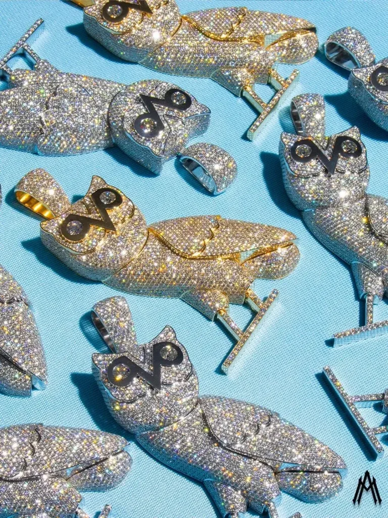 Multiple diamond-encrusted OVO owl pendants, illustrating the transition from raw materials to high-value branded intellectual property.