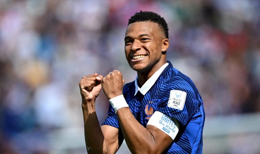 Kylian Mbappé celebrating in his French national team kit with a captain's armband, illustrating the prominent role of African football diaspora players in European teams.
