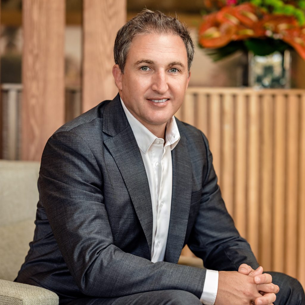 Vincent Hardy, CEO of Mont Choisy Group, wearing a grey suit jacket and white shirt, sitting for a professional headshot in Mauritius.